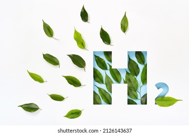 H2 Hydrogen Icon Made Of Cut Paper And Green Leaves On Blue Background. Emission-free Biofuels Concept