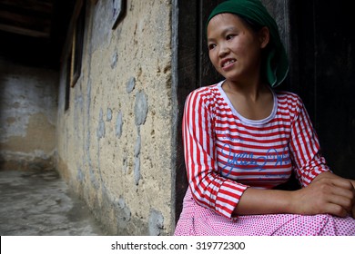 Ha Giang, Vietnam - September 19, 2015: Hmong girl in Vietnam with ancient houses built with clay. In the northern province of Ha Giang in Vietnam. An area adjacent to China.