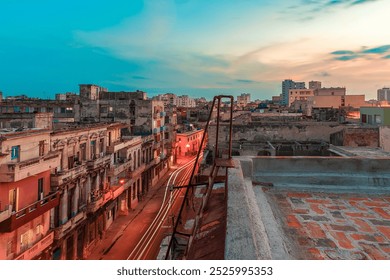 Habana, Cuba, at sunset, contrast between the vibrant sky and the weathered buildings. The warm glow of streetlights illuminates the narrow streets below, while light trails from moving vehicles.  - Powered by Shutterstock