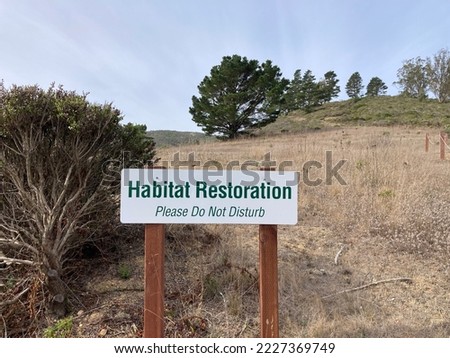 Habitat Restoration sign posted outdoor on wooden posts
