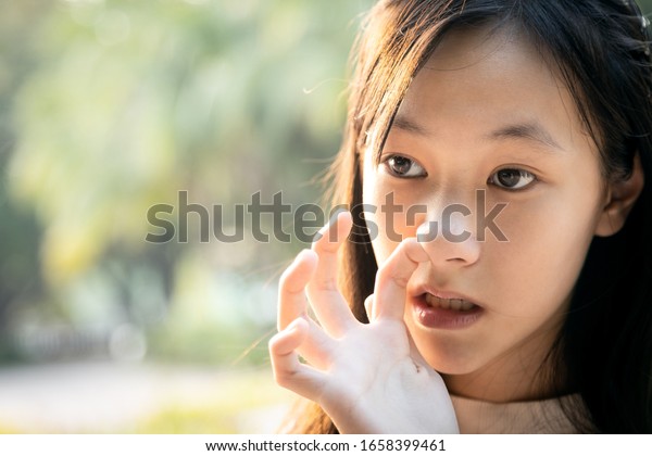 Habitual behavior of asian child girl is enjoy\
with finger in her nostril,hands do not wash,dirty,risk of\
bacterial infection into the body,woman is picking her nose due to\
itchy nose,nasal\
irritation