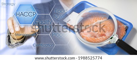 HACCP (Hazard Analyses and Critical Control Points) - Food Safety and Quality Control in food industry - concept with fresh fish salmon, plastic trayand magnifying glass