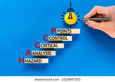 HACCP symbol. Concept words HACCP hazard analysis critical control point on wooden block. Beautiful blue background. Business HACCP hazard analysis critical control point concept. Copy space.