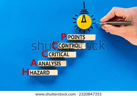 HACCP symbol. Concept words HACCP hazard analysis critical control point on wooden block. Beautiful blue background. Business HACCP hazard analysis critical control point concept. Copy space.
