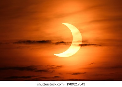 HACKENSACK, NJ  - JUNE 10, 2021: The Sun takes on a "crescent" shape during the Annular Solar Eclipse of 2021 shortly after sunrise over the horizon of the New York City and New Jersey.
