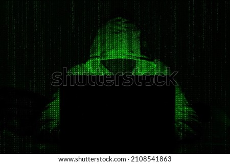 Hacker. Hacker attack. Developer. Software developer. Bandit. Criminal. Attack. information attack. Information. Cryptocurrency. Bitcoin. Computer. Green hacker. Darkness. Darknet. Masked man. Mask.