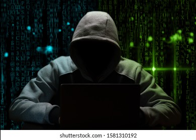 Hacker breaks the digital password, sitting in the dark at the computer on a background of binary code