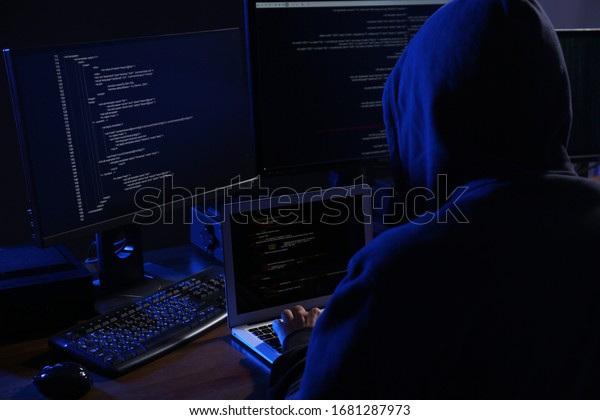 Hacker with\
computers in dark room. Cyber\
crime