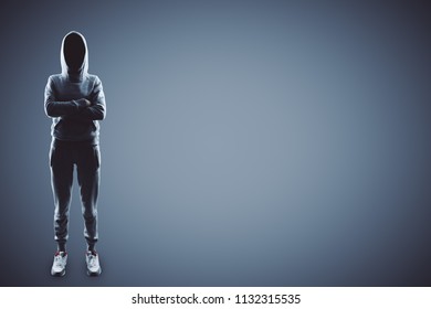 hacker with crossing hands in sport suit at grey background.