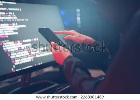 Hacker in dark room using keyboard stealing data on internet.