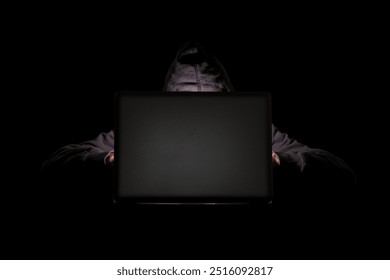 Hacker in a dark room using a laptop with copy space, internet phishing, hacking, and personal information theft, data security threats