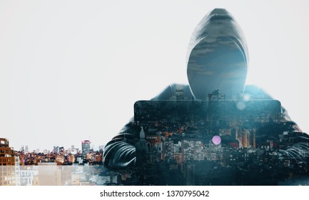 Hacker at desktop using laptop on white glowing night city background. Technology and theft concept. Double exposure 
