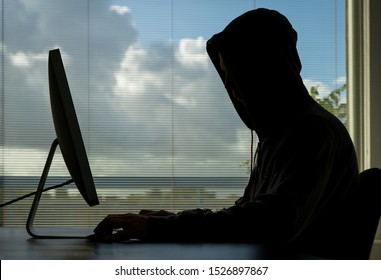 Hacker doing his crime on a desktop computer in broad daylight.