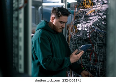 Hacker or engineer in data center holding tablet steals software checks information from server cloud storage technologies
