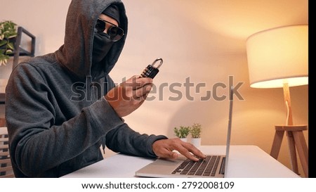 A hacker examines a padlock, symbolizing an attempt to crack security codes. This scene highlights digital vulnerability, data protection, password hacking, and the constant threat to cybersecurity.