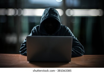 Hacker in front of his computer. Dark face - Shutterstock ID 381063385