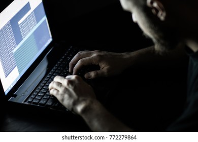 Hacker in front of his computer. Dark face