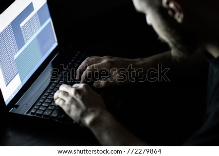 Hacker in front of his computer. Dark face