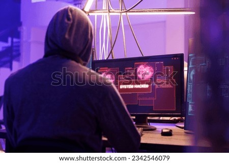 Hacker getting system hacked notification on computer screen after breaking into database server. Criminal in hood hacking website to steal confidential information at night