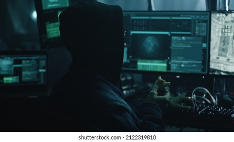 A Hacker In Glasses At A Computer With Software, During A Cyber Attack On The Docking Of The Space Module To The International Space Station In Dark Refuge. Footage On The Screeen Furnished By NASA.