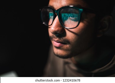 Hacker In Glasses And A Hood Works At A Computer In The Dark, A Reflection In Glasses Close-up, 4k