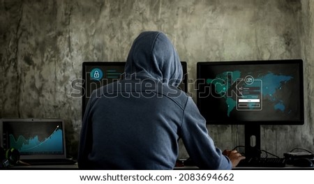 Hacker, hacker hacks network, hacker on a dark background. Dangerous Hooded Hacker Breaks into Government Data Servers