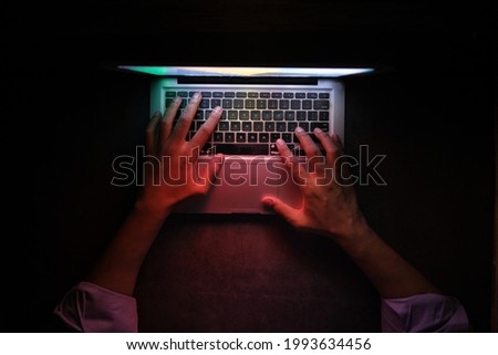 hacker hand stealing data from laptop top down 