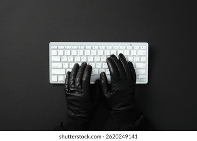 Hacker hands in black gloves typing on white keyboard. Cybercrime concept