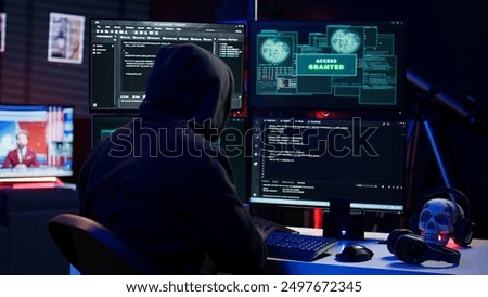 Hacker happy after successfully doing computer sabotage using ransomware, seeing access granted message. Cybercriminal successfully gaining access to victim data, demanding ransom money, camera B