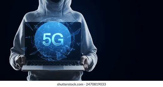 Hacker holding laptop with creative polygonal globe with 5g internet hologram on dark background with mock up place. Technology, data and future and mobile internet concept
