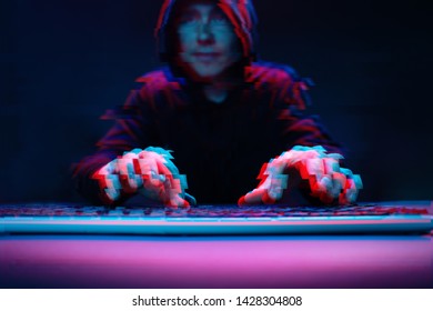 Hacker in the hood working with computer typing text in dark room. Image with glitch effect
