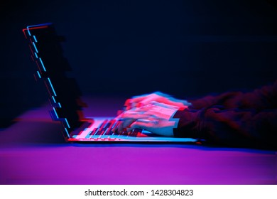 Hacker in the hood working with laptop typing text in dark room. Image with glitch effect - Powered by Shutterstock - Get 15% off with code: PIKWIZARD15