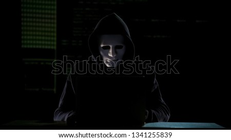 Hacker in hoodie cracking codes on laptop, cyberterrorism, internet security