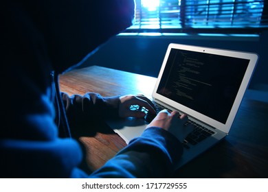 Hacker With Laptop In Dark Room. Cyber Crime