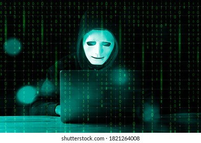 Hacker and malware concept. Dangerous Hooded hacker man using laptop with binary code digital interface.