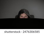 Hacker, man with laptop, hooded figure, cyber stalker, internet threat.