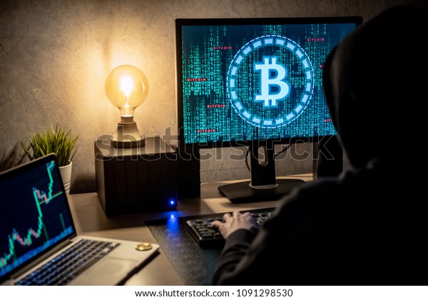 Hacker man\
using laptop and computer with Bitcoin green binary graphic and\
cryptocurrency candlestick graph price on monitor screen. Cyber\
crime digital currency laundering\
concept