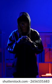 Hacker operating smartphone to execute phishing scheme and steal sensitive information through cyber intrusion