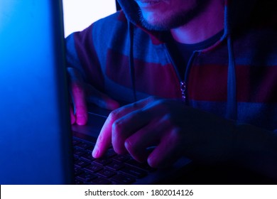 Hacker Or Programmer Typing On A Keyboard In A Room In The Dark, Young Man Hacking Computer