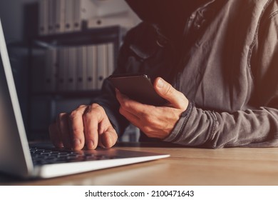 Hacker stealing data from jailbroken phone and attacking connected networks and systems, hooded male person hacking modern smart device, selective focus