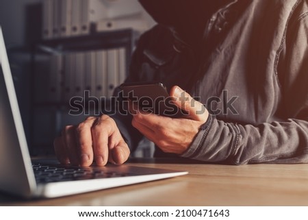 Hacker stealing data from jailbroken phone and attacking connected networks and systems, hooded male person hacking modern smart device, selective focus