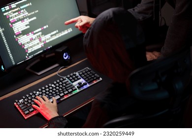 Hacker team using smartphone and typing code on keyboard to hacking programming system or server.