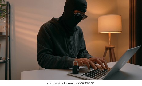A hacker types on a laptop next to a padlock, highlighting the ongoing battle between online security and cyber threats. The scene shows hacking, digital risk, privacy, and cyber defense.
