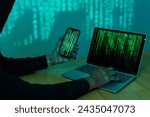 Hacker using computer for organizing massive data breach attack on goverment servers. Hacker in dark room surrounded computers