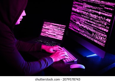 Hacker using computers in dark room