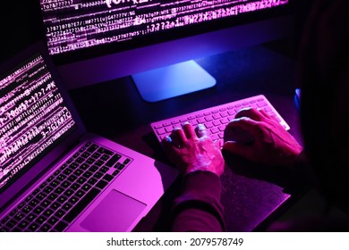 Hacker using computers in dark room