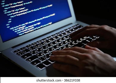 Hacker using laptop, closeup - Shutterstock ID 386219338