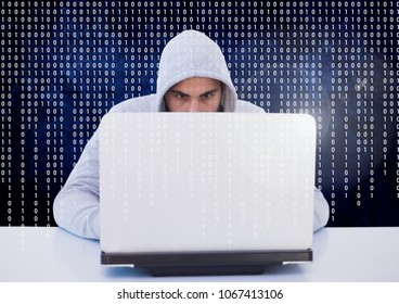 Hacker using a laptop in front of digital screen