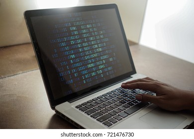 Hacker using laptop. Lots of digits on the computer screen.