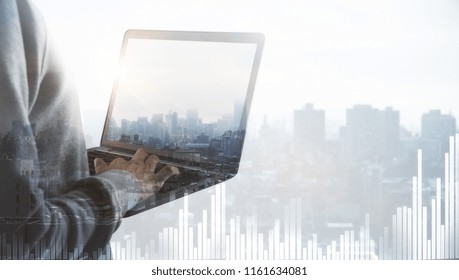 Hacker using laptop on abstract city background with chart and copy space. Finance, hacking and malware concept. Double exposure 